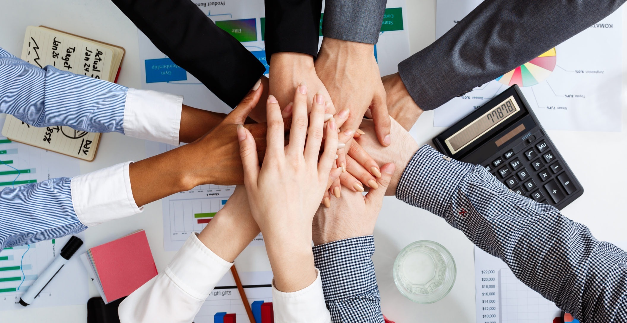 Picture of businessmen's hands on white table with documents, coffee and drafts